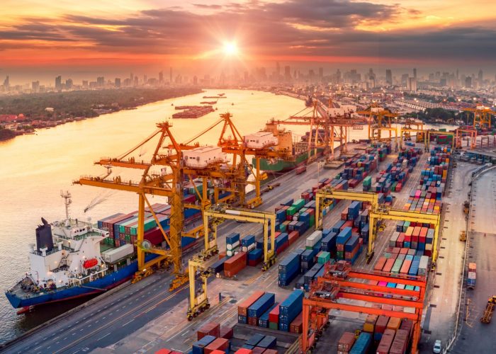 Logistics and transportation of Container Cargo ship and Cargo plane with working crane bridge in shipyard at sunrise, logistic import export and transport industry background